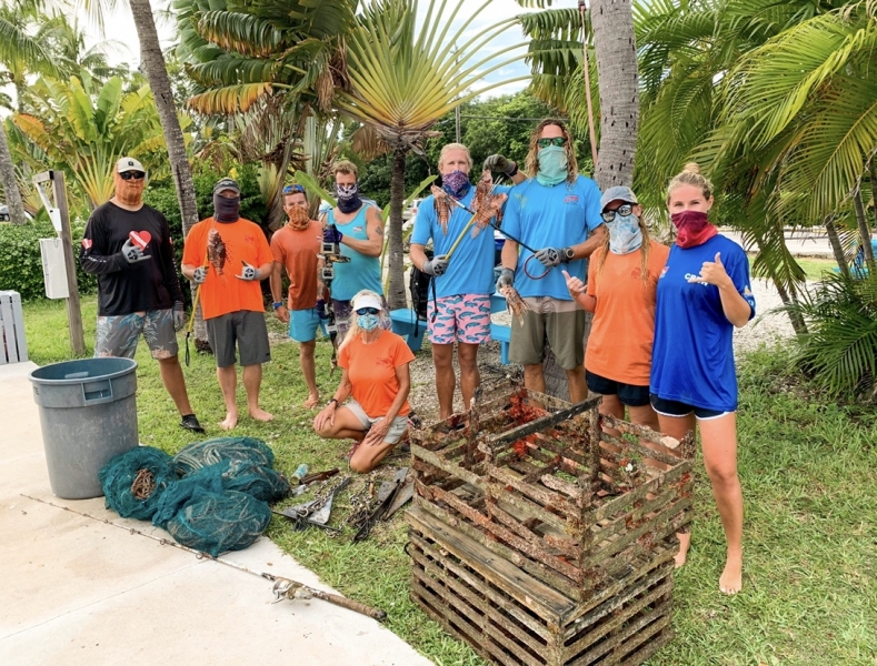 A group of divers posing with marine debris.