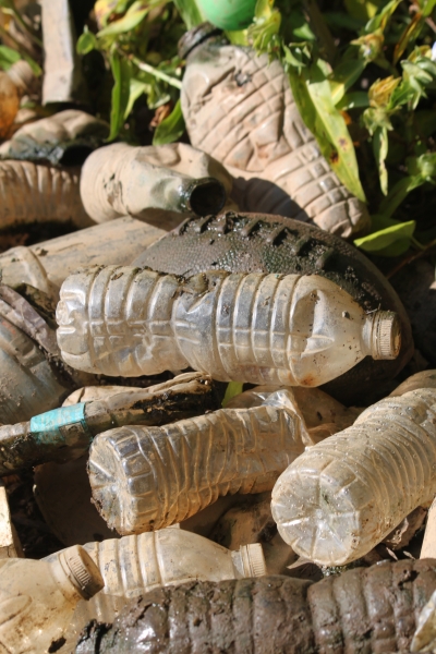 A football amid dirty plastic bottles.