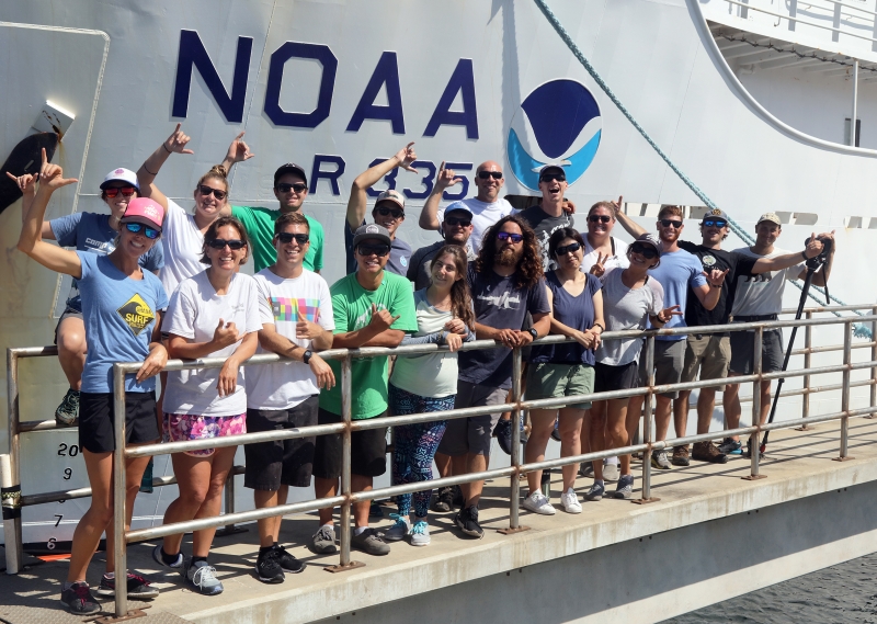 Team of people smiling on a large ship.