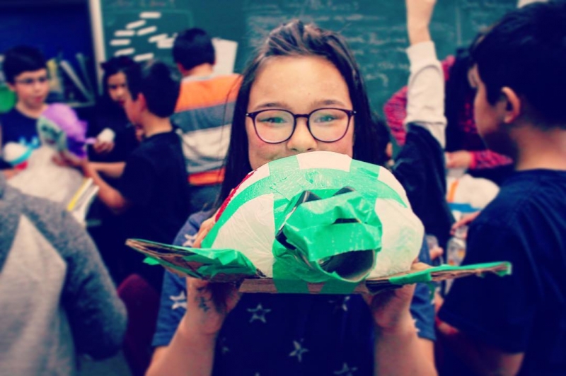 Girl holding a turtle sculpture.