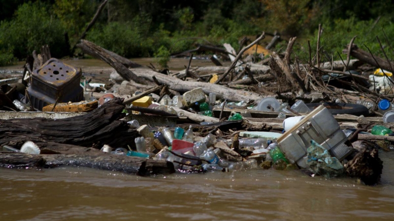 Logs and debris blocking a river.