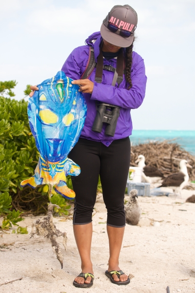 Researcher holding balloon debris and entangled Albatross.