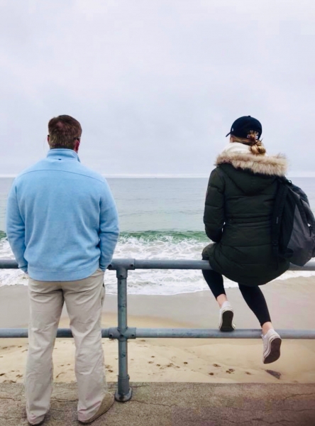 Father and daughter look out at the beach in Rockport, Massachusetts. 
