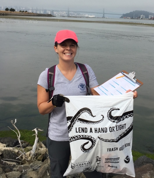 Woman holds bag of debris.
