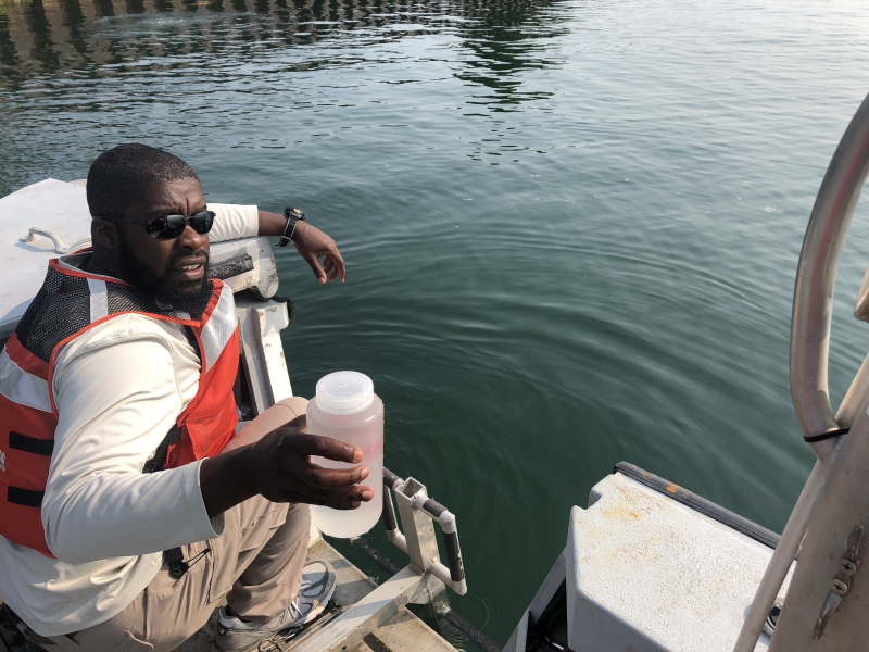 Man in a boat with a jar of water. 