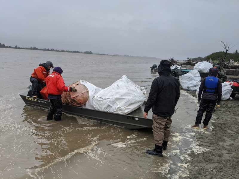 U.S. Forest Service staff removing debris and loading it into boats for sorting and disposal.