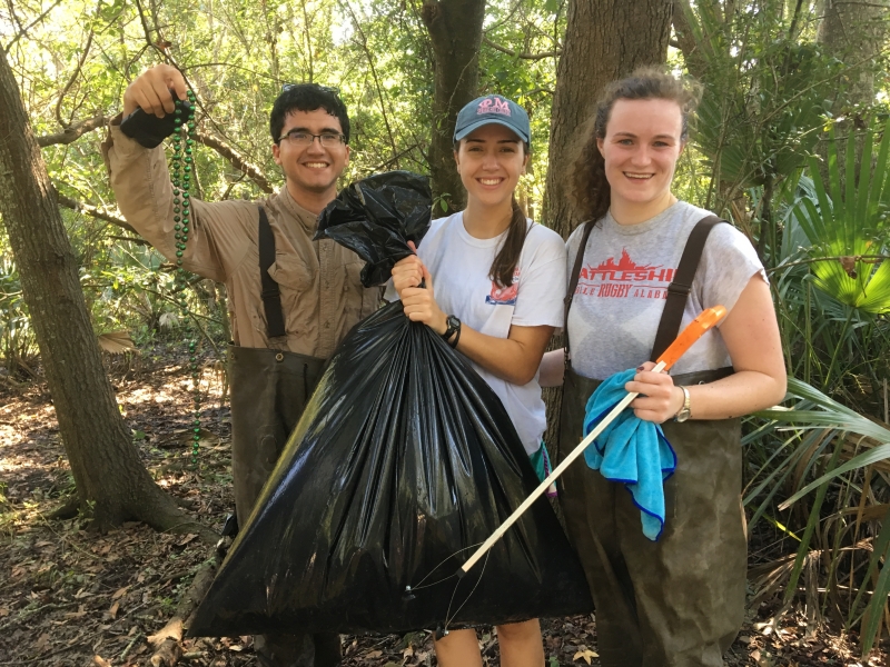 Volunteers hold up their marine debris haul.