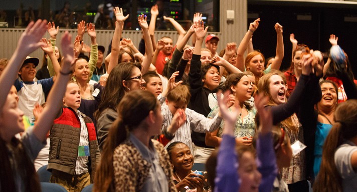 Students raise their hand during a plastic pollution summit at Monterey Bay Aquarium