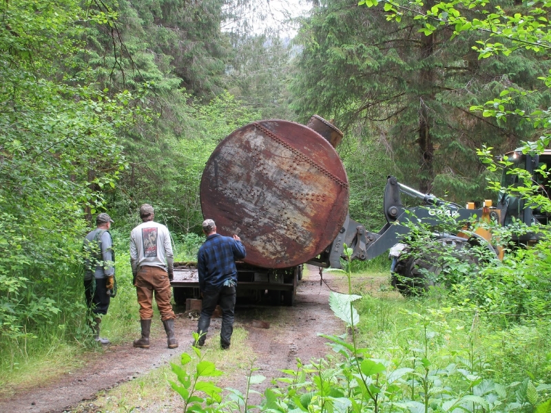 Two large metal fuel containers being removed.