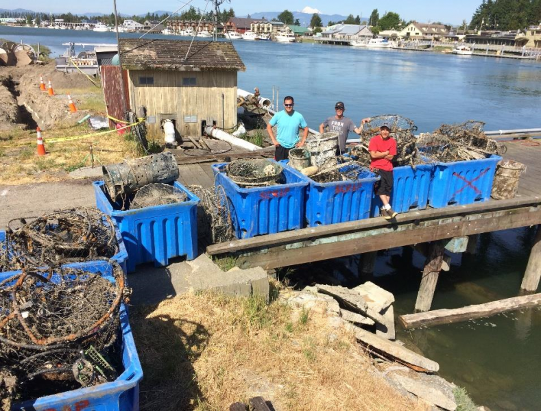 A removal team stand next to piles of collected marine debris.