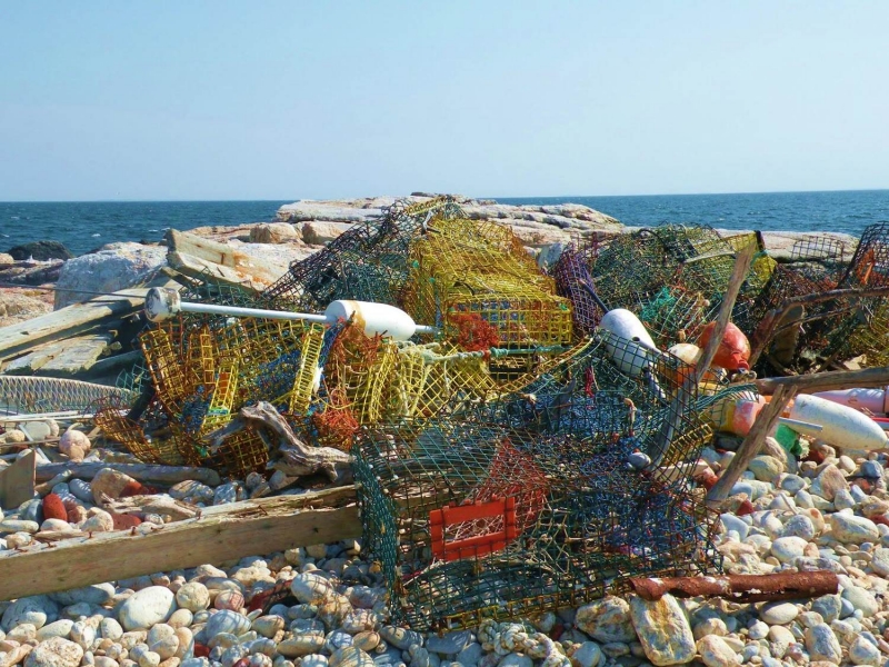 A pile of collected crab traps on a beach.