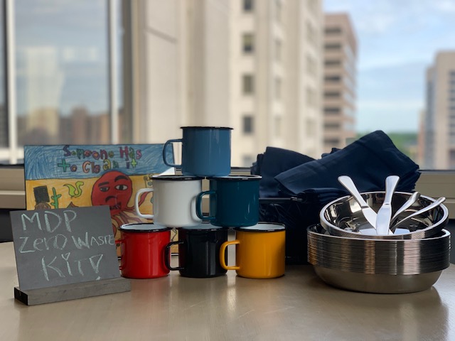 A zero waste kit containing reusable plates, utensils, cups, and napkins.