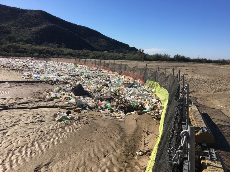 Trash boom with lots of debris against it.