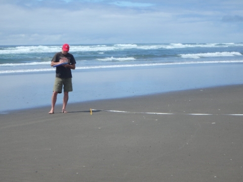 Chris Wilcox filling out a form on a beach.