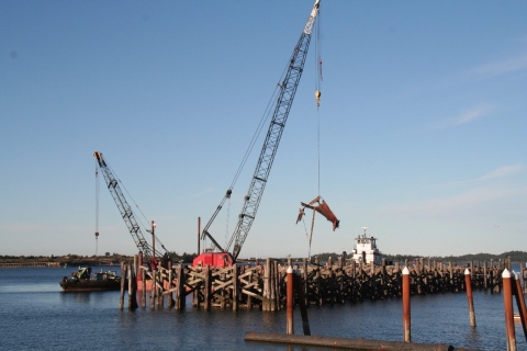 Boat debris being hauled out of the water with a crane.
