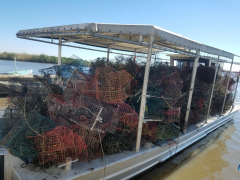 A boat that is full of collected, discarded crab traps that have been removed from the water.
