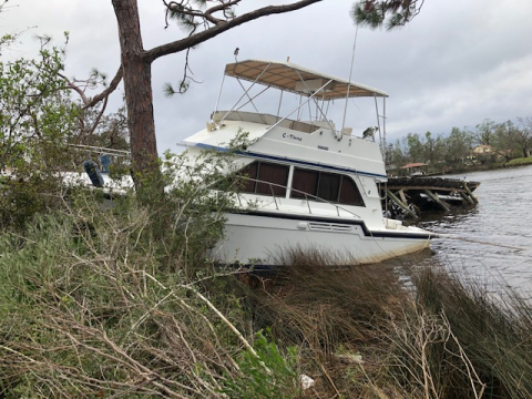 A derelict vessel grounded on the shore.