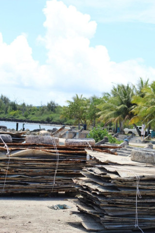 Two stacks of metal panel debris at a harbor.
