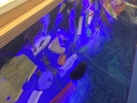 Plastic bottles, bags, and foam in a derelict net.