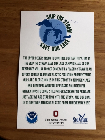 A sign is used in restaurants to encourage guests to "Skip the Straw and Save Our Lake".