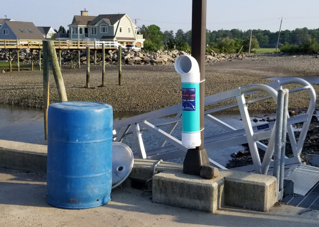 A fishing line recycling bin on a post at a pier.