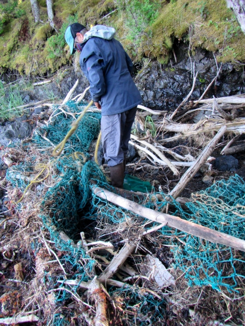 A volunteer standing in net debris.