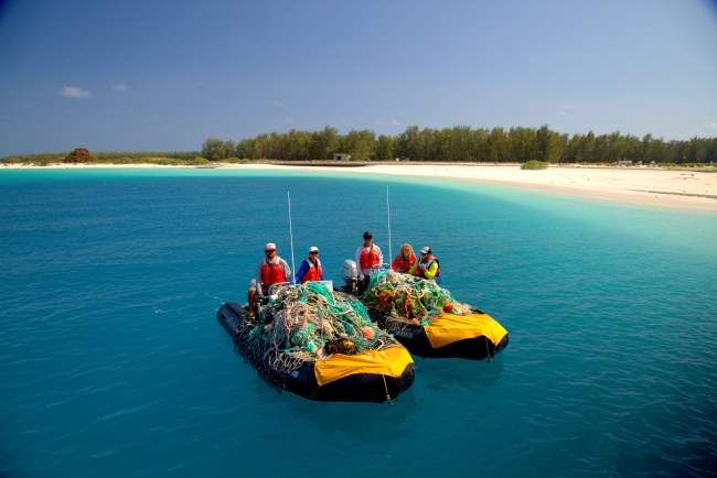 The Marine Debris team poses with 1,115 kg. (2,453 lbs.) of derelict fishing nets removed from the shorelines of Sand Island, Midway Atoll National Wildlife Refuge.