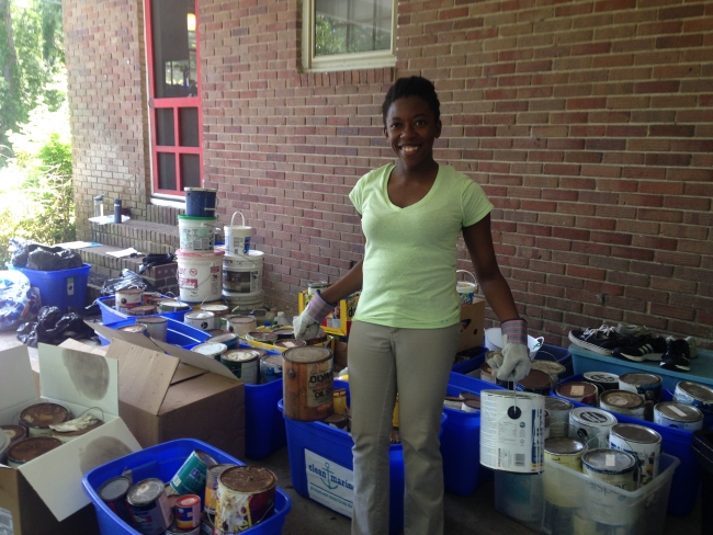A volunteer holding paint cans.