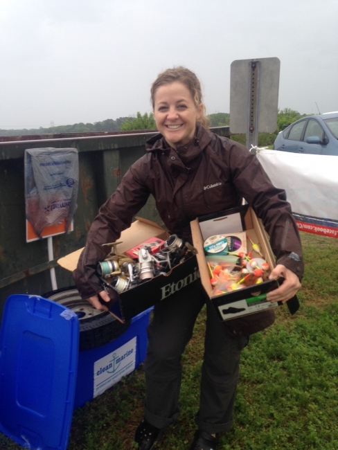 A volunteer holding boxes of collected line and lures.