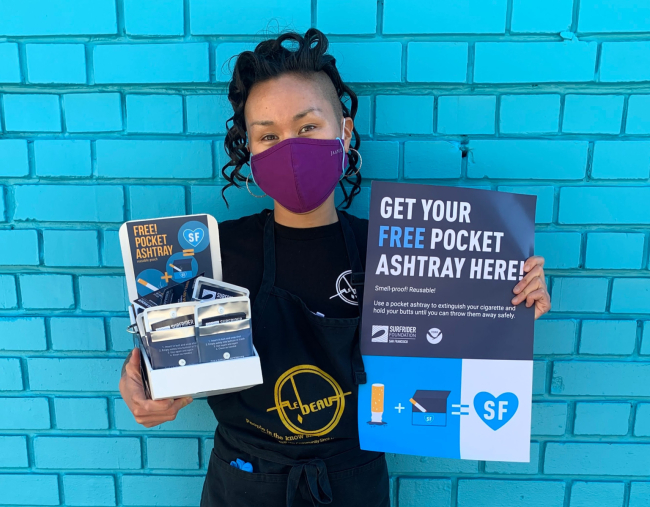 Restaurateur holds up a box of pocket ashtrays.