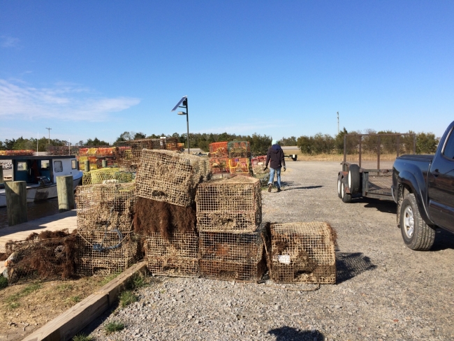 Derelict crab pots piled up in a parking lot.