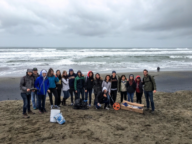 A group of students on a beach with monitoring equipment.
