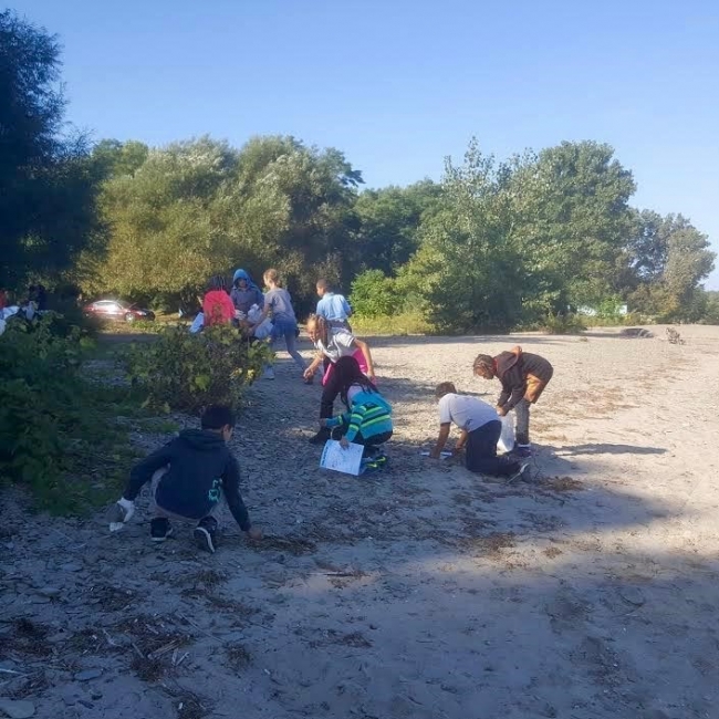 Students cleaning up a beach.