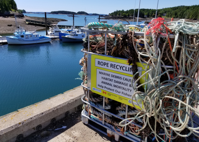 A disposal bin filled with ropes on a wharf.