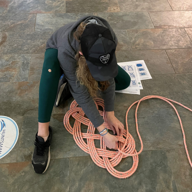 A person making a mat with discarded fishing rope.