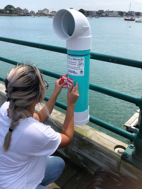 A person places a sticker on a bin.