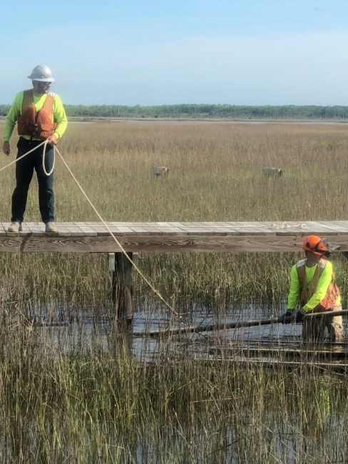 Contractors work to remove wooden dock debris. 