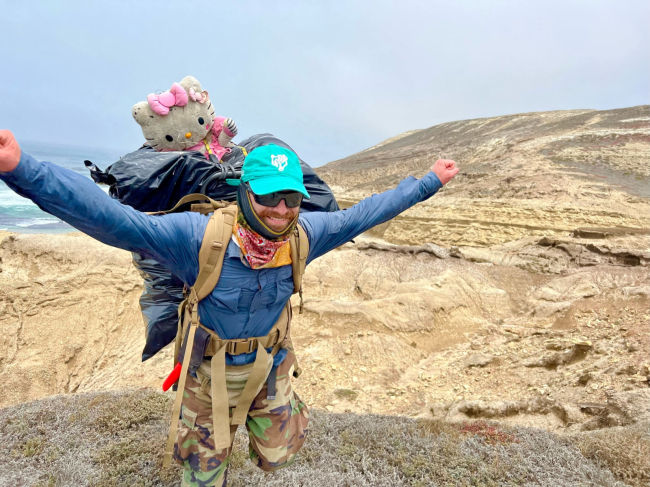 A team member carries removed debris on their back. 