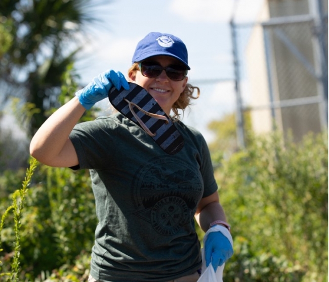 A NOAA team member holds up a flip flop. 