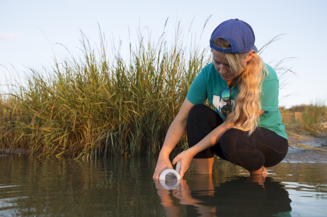 A participant collects a water sample.