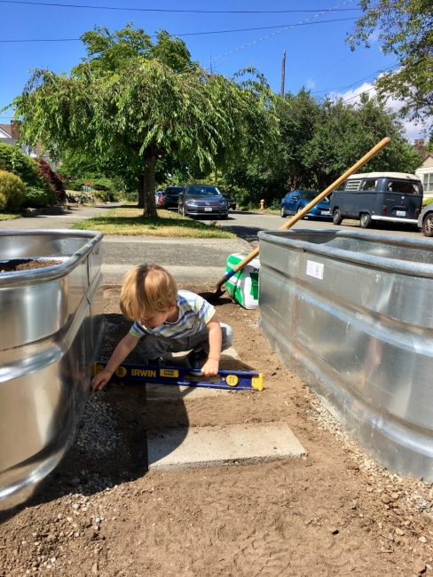 Young boy plays between planters. 