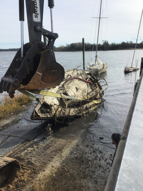 Crews remove an abandoned and derelict vessel from the water.