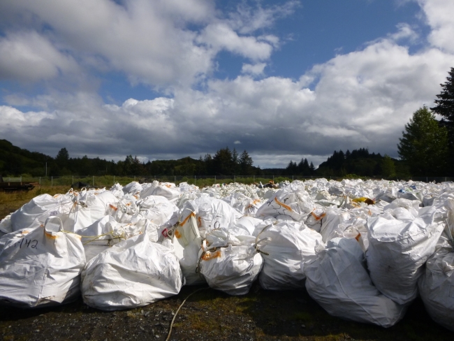 A pile of super sacks (plastic bags) filled with collected debris.