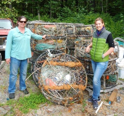 Two people standing next to derelict crab pots.