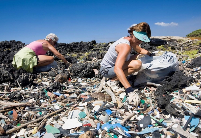 People cleaning up plastic debris from a beach.