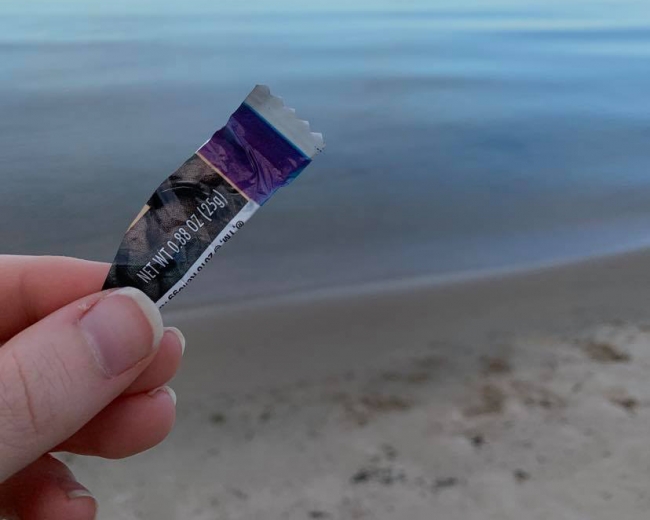 Hand holding a piece of plastic wrapper.