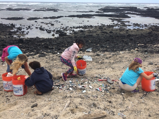 Students picking up debris on a beach.