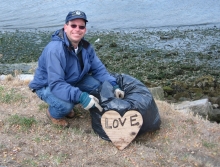 Man with plywood heart that says "love". 