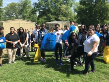 A group of students hold up full garbage bags.