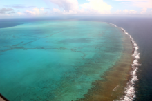 An aerial photograph of the barrier reef of the Midway Atoll.